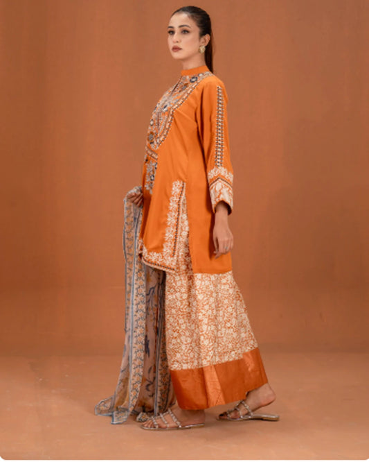Woman wearing orange embroidered 3pc suit, side pose showing dupatta drape