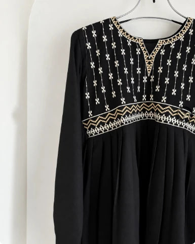Close-up of gold and white cross-stitch embroidery on black cotton peplum kurti