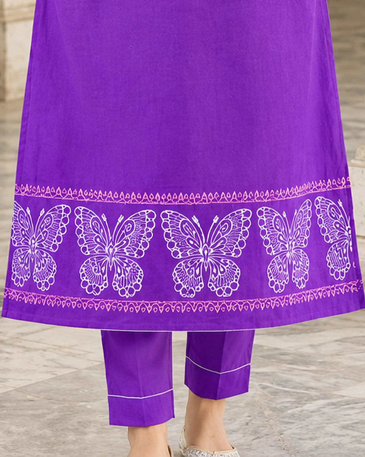 Butterfly block print border along the hem of a purple cotton kurta