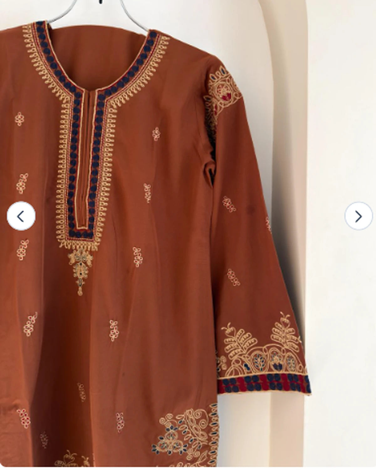 Close-up of gold and navy embroidery on rust brown kameez neckline
