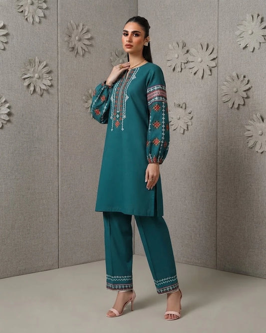 Woman wearing teal embroidered cotton two-piece set, side angle pose