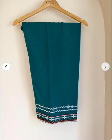 Teal embroidered cotton pants with embroidered hem, on hanger